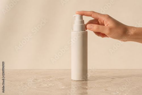 Female Hand Pressing Cosmetic Pump Bottle