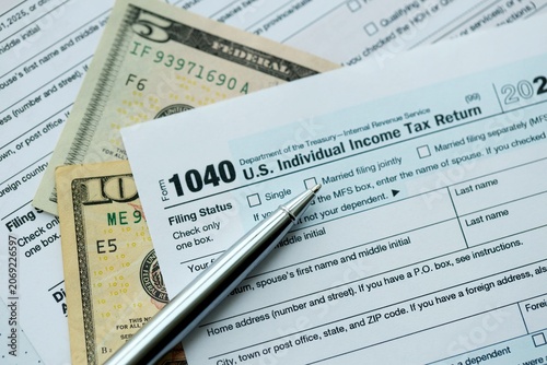 Photography 1040 Individual Income tax return form and pen with dollars money bills on accou