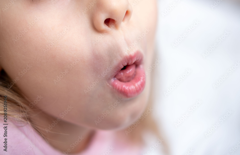 Fototapeta premium Child rolling tongue, Young girl sticking out tongue, playful expression, tongue visible, speech therapy, pronunciation practice session, practicing sounds, oral anatomy health, dental tongue exercise