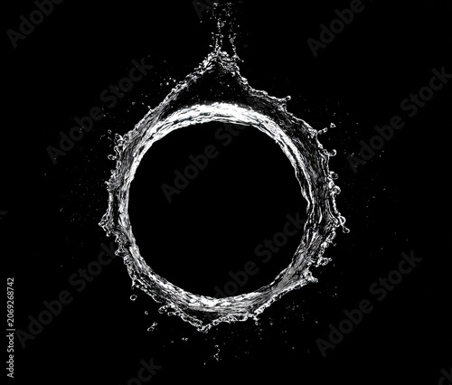 Water droplets forming a perfect ring, suspended against a stark black backdrop
