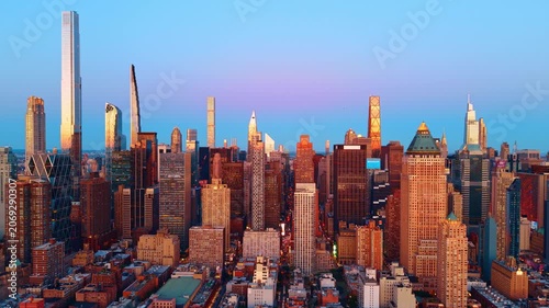 Midtown Manhattan skyline with supertall towers at dusk, New York. Central Park South supertalls and mixed-era buildings under a blue-to-pink gradient sky at twilight.