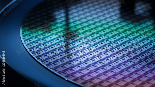 Computer Chip Manufacturing. Close-up of Colorful Semiconductor Wafer that is just was Diced during Microchip Packaging Process. Silicon Dies are being Extracted by a Pick and Place Machine