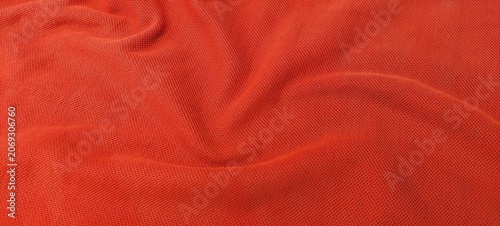Photos Orange sports clothing fabric in close up with football jersey texture