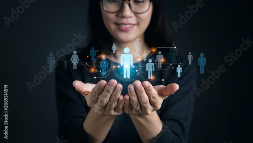 Woman's hands holding a digital network of people icons, representing connection and human resources