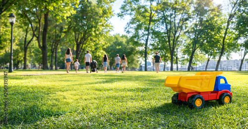 People enjoying a walk in a sunny urban park surrounded by green trees and blooming nature. Concept of healthy lifestyle, recreation, outdoor leisure, relaxation and seasonal activities.
