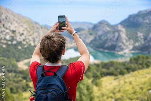 Mallorca, Spanien: Wanderung im Norden der Insel, Serra de Tramuntana zum Puig des Tossals Verds - Wanderin fotografiert mit Handy den Cuber Stausee