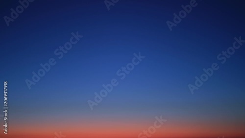 Blue sky at twilight transitioning into evening darkness, time lapse. Gradient of sunset fading into night with faint stars visible. Natural horizon background for peaceful night concept.