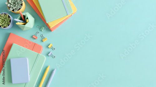 Colorful stationery and succulent plants arranged on a pastel blue background in flat lay style