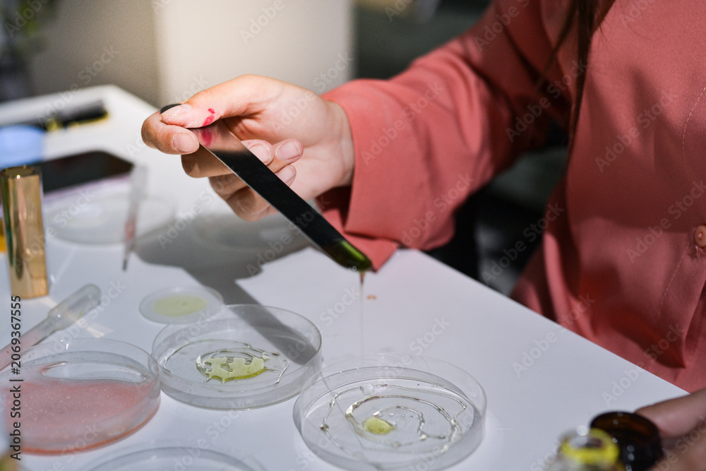 Obraz premium Woman making organic cosmetics with aloe in laboratory