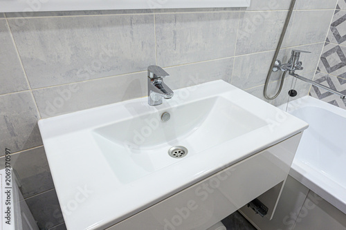 Konstfotografi compact white rectangular sink with chrome faucet sits atop minimalist vanity