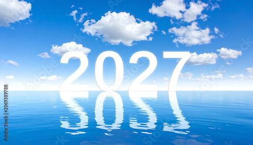 Year 2027 message reflected on ocean surface under blue sky with clouds, representing future, forecasting, and clarity