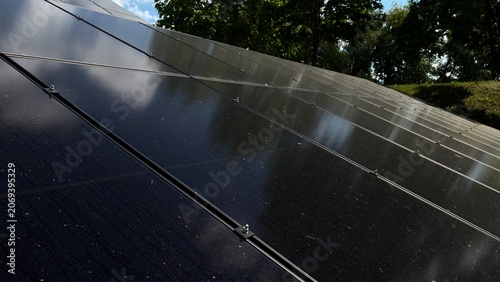 Solar Panels Reflecting Blue Sky and Clouds, Renewable Energy Concept, Clean Electricity Technology