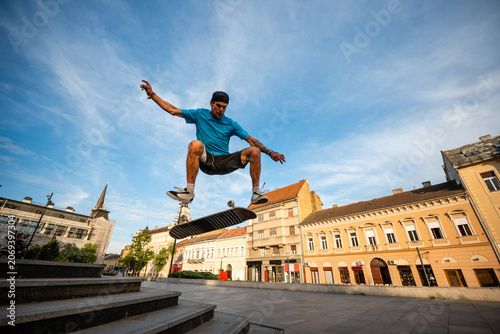 Φωτογραφία Skateboarder performing kickflip trick in urban square
