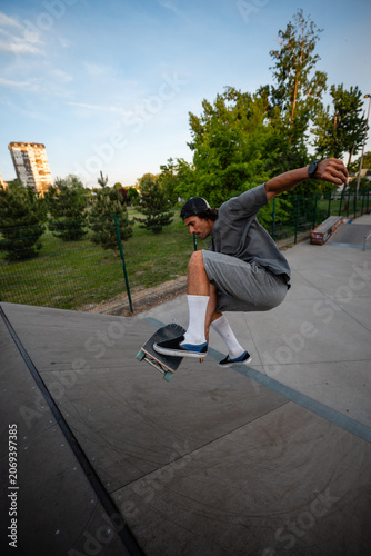 Φωτογραφία Skateboarder performing a kickflip jump in skatepark