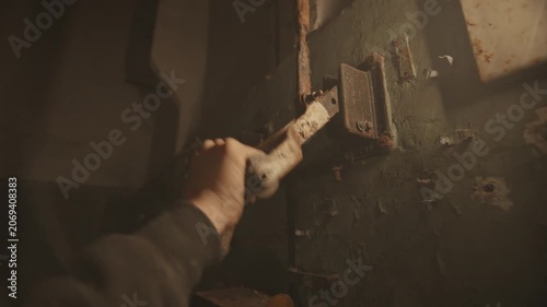 A hand operates a rusty industrial lever against a peeling wall. The concept highlights industrial history and vintage machinery, offering value in historical and industrial contexts.
