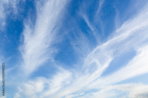 Blue sky background with delicate cirrus clouds creating an elegant natural background. Ideal for weather, nature, environment, travel and design concepts.