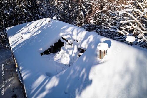 Принти на полотні Drone's eye view of a dilapidated, snow-covered roof with a gaping hole, belongi