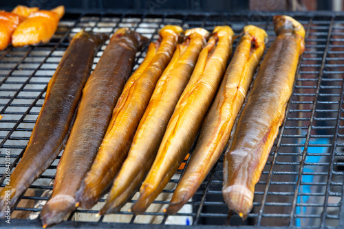 fresh smoked eels cooking on a grille
