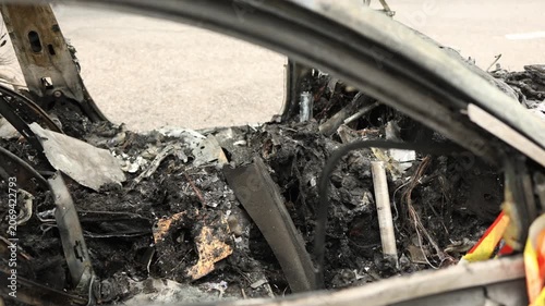 close view of a luxury car destroyed by fire revealing charred materials structural damage and the aftermath of an automotive emergency
