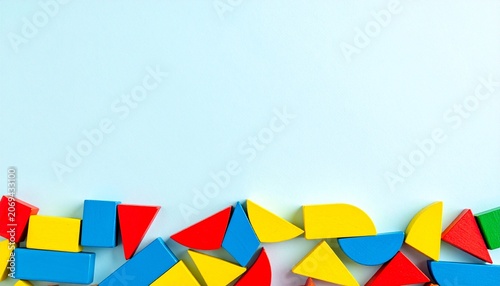 Colorful Geometric Wooden Blocks on Light Blue Background Representing Shapes, Creativity, Childhood Learning, and Motivational Spatial Exploration