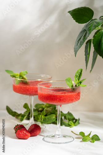 Two strawberry cocktails garnished with fresh mint for summer