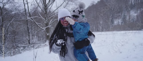 Happy Latina Mother with Baby Enjoying Snow in Germany During Winter