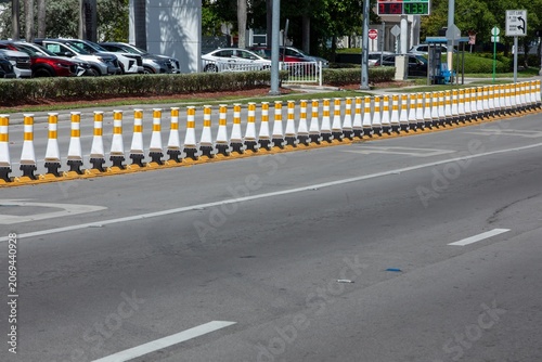 Foto Row of white and yellow traffic delineator posts on an asphalt road divider