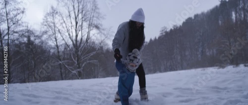 Happy Latina Mother with Baby Enjoying Snow in Germany During Winter