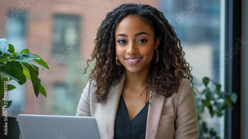 Young Woman Working on Laptop in Modern Office with Natural Light