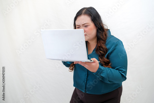Foto Woman holds laptop, eyes closed, showing displeasure