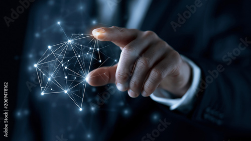 Businessman interacting with futuristic digital network interface glowing in dark