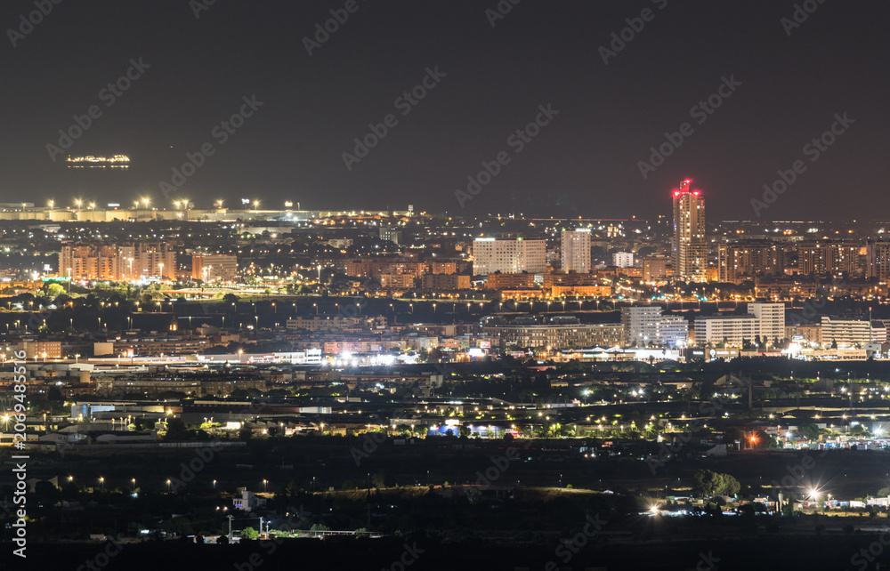 Obraz premium Valencia Cityscape at Night Featuring Torre de Francia and Modern Urban Architecture