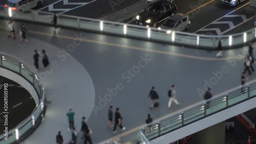 TOKYO, JAPAN - JUNE 2026 : Aerial view of crowd of people walking at the pedestrian deck. Street traffic and highway overpass. Japanese city traffic and transportation concept, time lapse video.