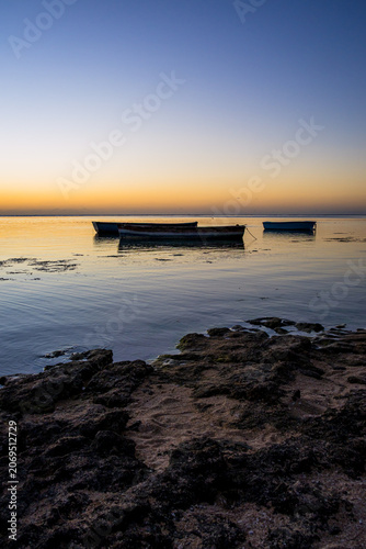 Couché de soleil et bateaux de pêche depuis une plage au Nord-Ouest de l'Ile Maurice, Océan Indien, Afrique