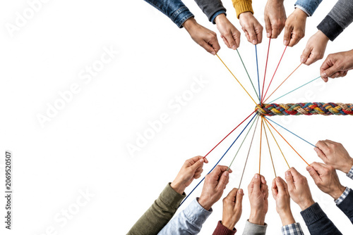 Many hands pull colorful threads from a braided rope. Space for text.