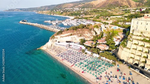 Stunning overhead drone perspective capturing the endless golden beaches dotted with colorful umbrellas, the medieval city center with its narrow cobblestone streets
