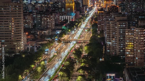 Time-lapse footage of traffic light trails and residential areas in Beijing's East Third Ring Road, showcasing urban development.
