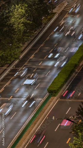 Long exposure light trail time-lapse of urban night scene elevated traffic flow