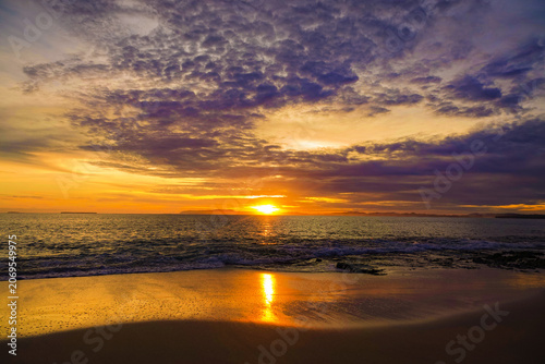 Photos LENS FLARE: Spectacular sunset bathes a remote sandy beach in a vibrant palette of orange and gold