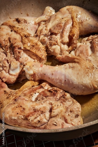 Whole chicken legs and thighs browning in a pot.