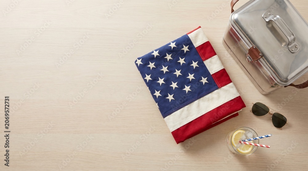 Obraz premium Folded american flag resting on a wooden table with a metal lunchbox and cold drink