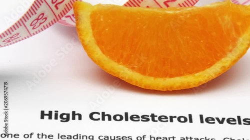 Orange Slice and Measuring Tape on High Cholesterol Health Awareness Document