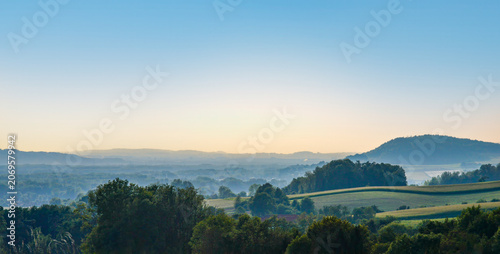 Misty Rolling Hills and Rural Landscape at Sunrise