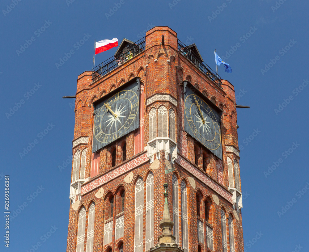 Obraz premium Close view of the Gothic clock tower of the historic Town Hall in Torun, Poland.