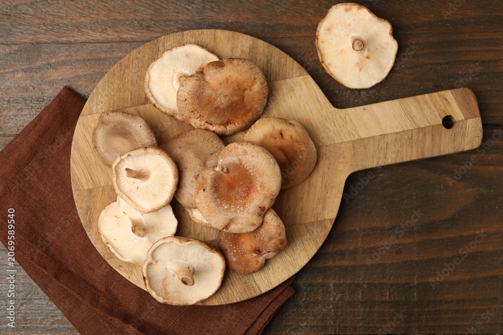 Fototapeta premium Raw shiitake mushrooms on wooden table, flat lay