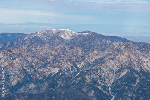 Aerial view of snow-capped Mt. San Antonio (Mt. Baldy), the highest peak in the San Gabriel Mountains, with the Los Angeles basin visible in the distant haze, California, USA