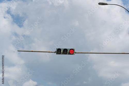 Red Traffic Light Against Cloudy Sky