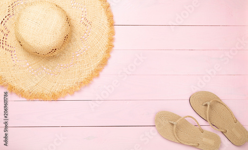 Straw hat with beach accessories on color background, top view