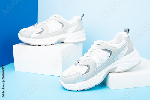 Pair of sneakers on color background