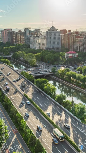 Traffic congestion delayed at overpass along Beijing's moat in the afternoon sun.